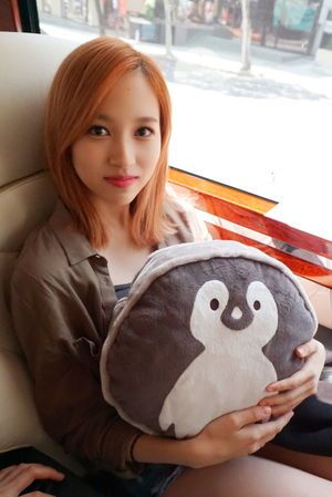Photo : Mina cuddling her penguin cushion